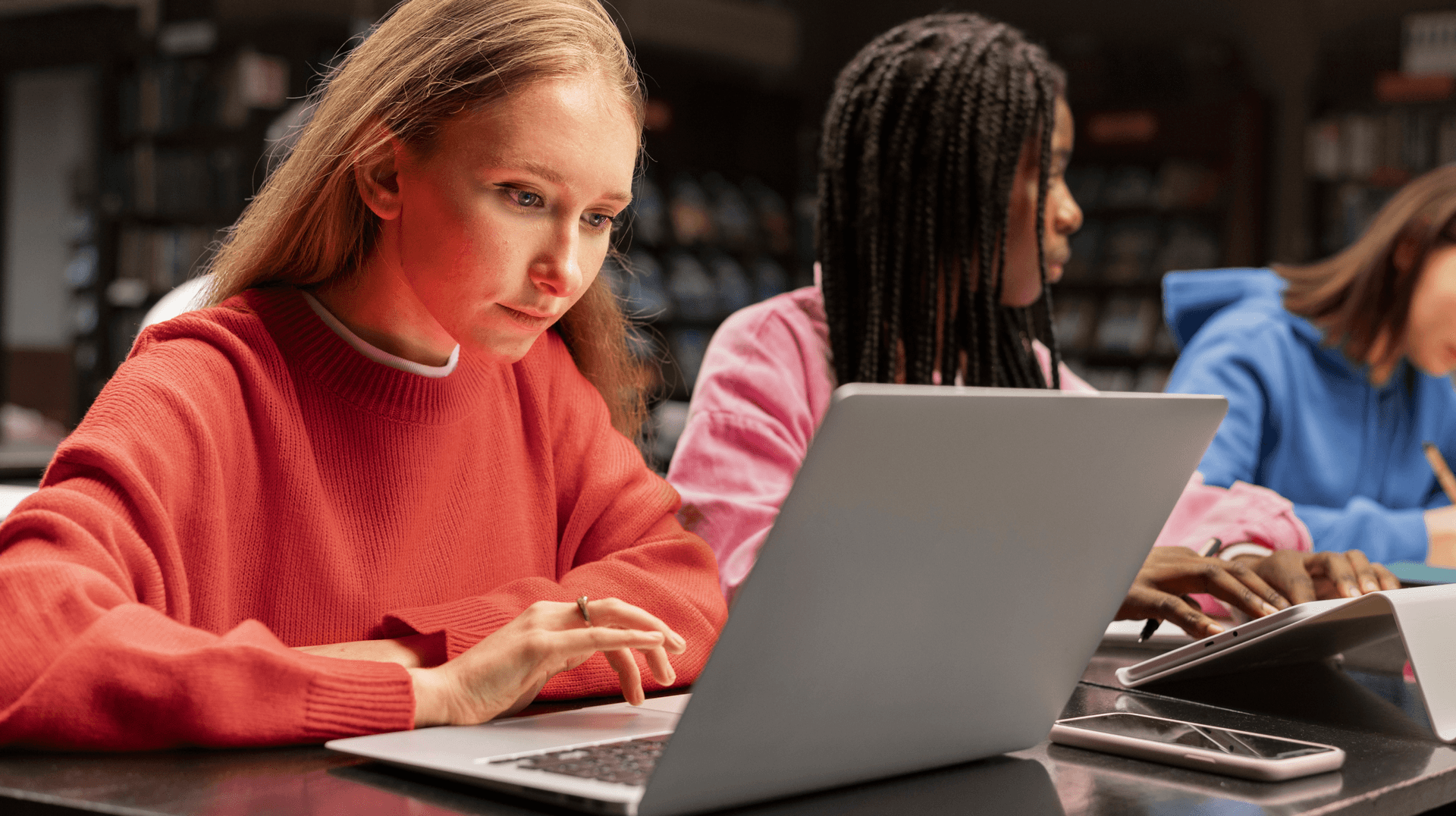 three-young-people-in-the-office-looking-at-computer-working-studying-clasrrom-lab-room